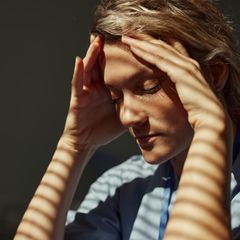 Frau fasst sich gestresst an den Kopf