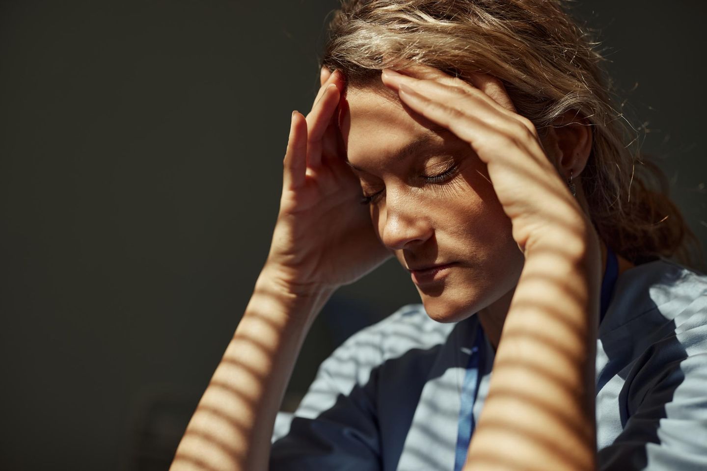 Frau fasst sich gestresst an den Kopf
