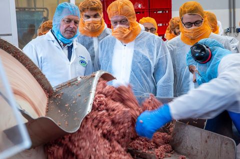 Zu Besuch in einer mecklenburgischen Wurstfabrik: Mit dem Fleischwolf kennt sich Landwirtschaftsminister Alois Rainer (Mitte), selbst Rekordhalter im Wurstmachen, aus