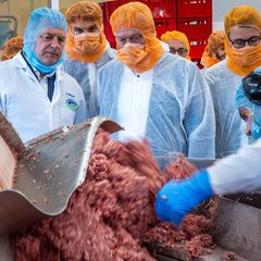 Zu Besuch in einer mecklenburgischen Wurstfabrik: Mit dem Fleischwolf kennt sich Landwirtschaftsminister Alois Rainer (Mitte), selbst Rekordhalter im Wurstmachen, aus