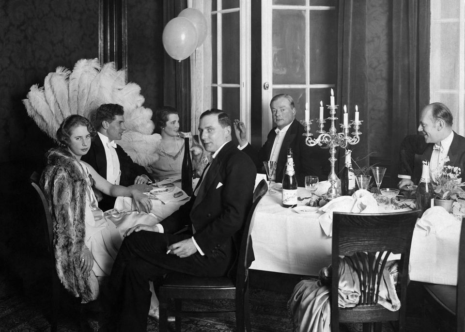 Claerenore Stinnes sitzt mit anderen Menschen an einem Tisch