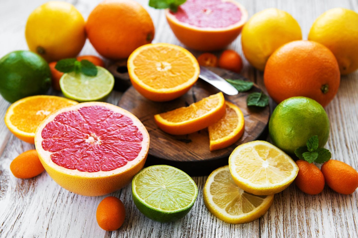 Frische Zitrusfrüchte auf einem weissen Holztisch