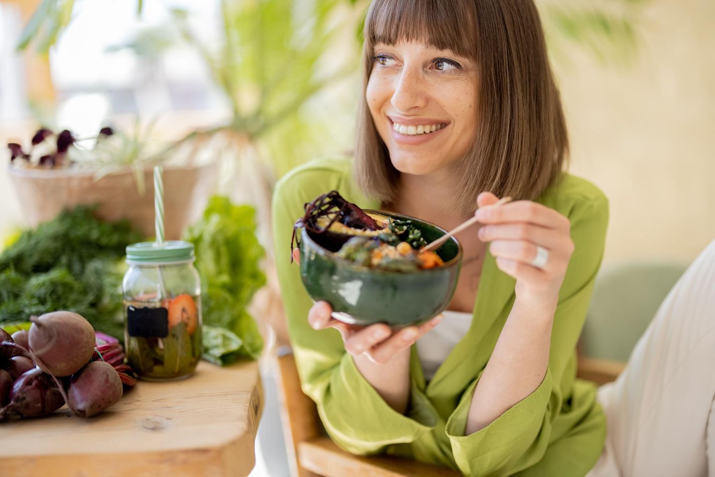 Junge fröhliche Frau isst eine vegetarische Bowl