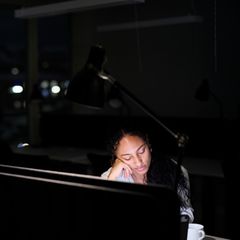 Eine Frau sitzt noch spätnachts vor einem Computerbildschirm