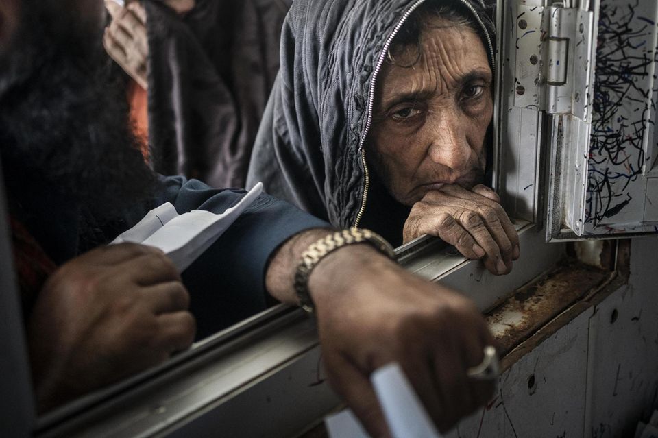 Eine alte Person steht am Fenster einer mobilen Gesundheitsstation