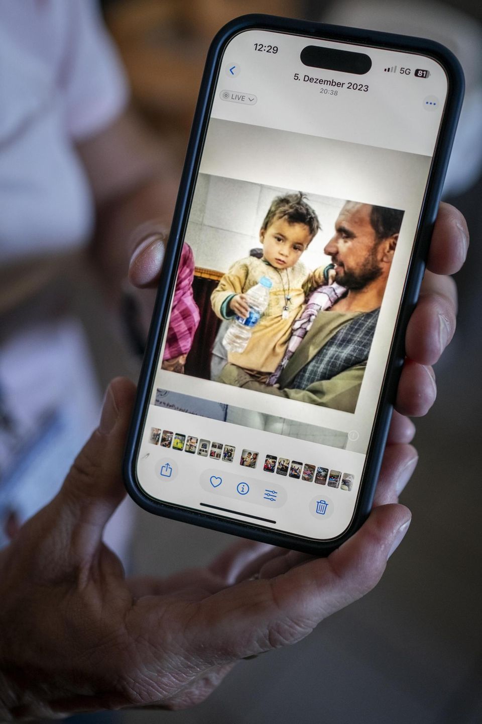 Ein Handybildschirm, welches ein Kind zusammen mit seinem Vater zeigt