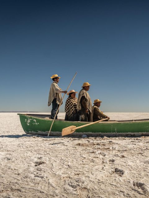 Auf der schier endlosen Salzfläche des ausgetrockneten Poopó-Sees versammeln sich Florencio, Pablo, Cipriana und Félix Mauricio in einem Boot. Ein Relikt aus Zeiten, in denen hier noch Fische statt Staub ihr Dasein bestimmten. Die Qotzuñi haben ihre traditionelle Existenz verloren: Mit dem Klimawandel, dem Wasserentzug für Landwirtschaft und Bergbau verschwand eines der größten Binnengewässer Boliviens fast vollständig. Heute widmet sich die Gemeinschaft dem Kunsthandwerk, um Erinnerung und Identität zu bewahren. Die Inszenierung auf der dürren Ebene ist eine Art Denkmal: für eine Kultur, die sich neu erfinden musste, und für ein Ökosystem, das nicht zurückkehren wird.