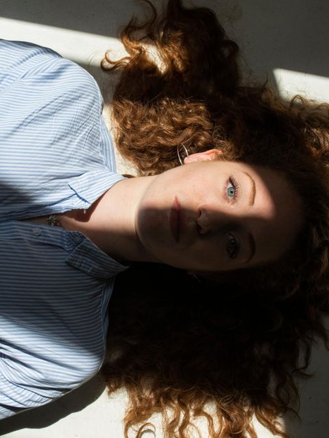 Eine Frau liegt entspannt auf dem Rücken. Sonne fällt durch ein Fenster auf ihr Gesicht