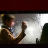 Mann sitzt hinter Frau im Bus