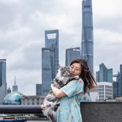 Terrie Jin mit Katze auf dem Arm vor der Skyline