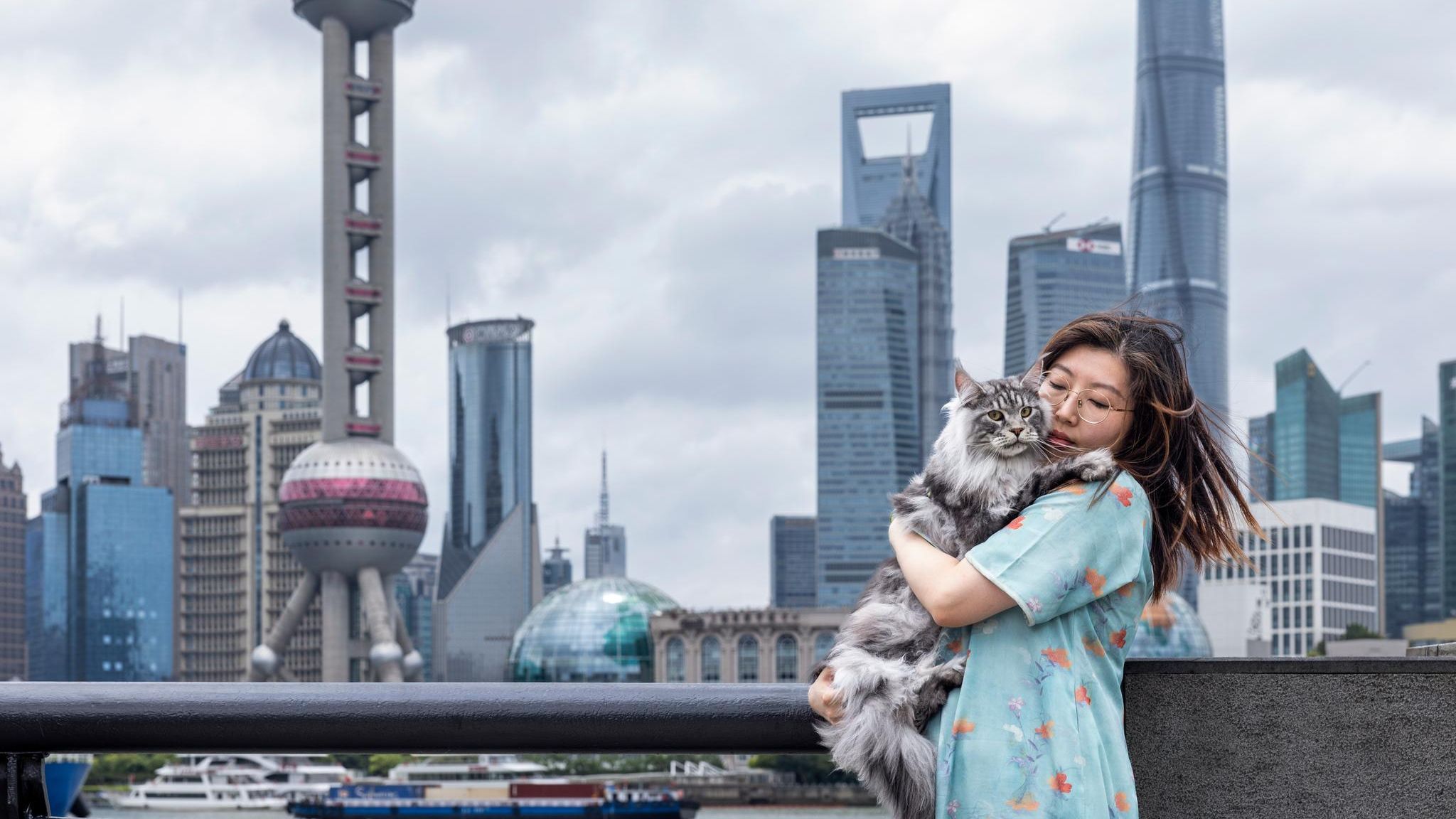 Terrie Jin mit Katze auf dem Arm vor der Skyline