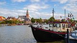 Der Stadthafen von Leer in Ostfriesland mit Schiffen und Blick auf das Rathaus.