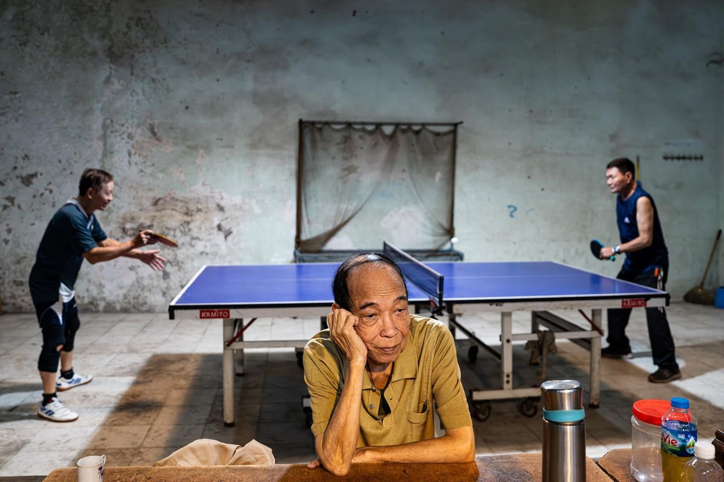 Hängt er seinen Gedanken nach, während zwei pensionierte Offiziere Tischtennis spielen? Oder ist er genervt vom lebhaften Match hinter seinem Rücken? Was den Mann im Vordergrund beschäftigt, bleibt offen – Fotograf Rahsan Firtina verrät es nicht. Doch gerade der Kontrast belebt sein Porträt einer Alltagsszene in Hanoi und verleiht dem Bild dazu einen Hauch von Komik.