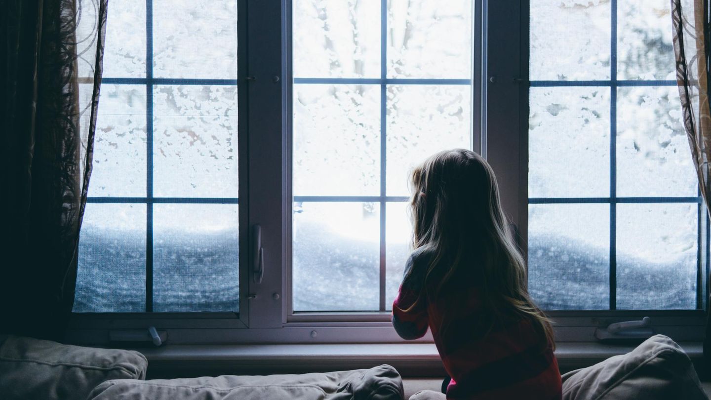 Mädchen vor Fenster im Winter