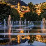 Durchatmen, abkühlen, schlendern: Die Promenade du Paillon zieht sich wie ein grünes Band vom Théâtre National de Nice und dem Museum für Moderne Kunst bis hinunter zum Meer. Auf rund zwölf Hektar wechseln sich Rasenflächen, Blumenbeete, Alleen, Spielplätze und Sitzbereiche ab. Herzstück der grünen Lunge Nizzas ist der Miroir d’Eau ("Wasserspiegel") am Place Masséna: eine weitläufige Wasserfläche mit zahlreichen Bodendüsen, die in Intervallen Fontänen und feine Nebelwolken in die Höhe schießen lassen. Besonders an heißen Sommertagen tobt hier das Leben: Kinder jagen kreischend durch die Wasserstrahlen, Erwachsene genießen den kühlenden Sprühnebel. Bei Windstille macht der Platz seinem Namen alle Ehre – dann spiegelt sich die Skyline der Stadt auf dem Wasser.