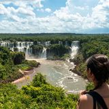 Panoramablick auf Iguazú-Wasserfälle, im Vordergrund Frau