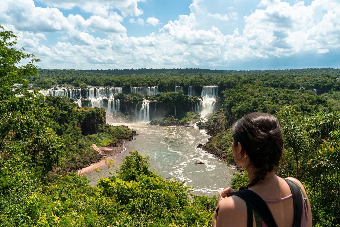 Panoramablick auf Iguazú-Wasserfälle, im Vordergrund Frau