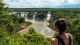 Panoramablick auf Iguazú-Wasserfälle, im Vordergrund Frau