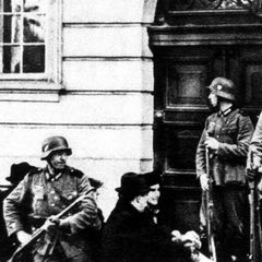 Bewaffnete Uniformierte mit Stahlhelmen vor einer Eingangstür; schwarz-weiß Aufnahme; NS-Zeit