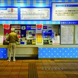 Eine Person steht am Ticketautomaten