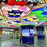 Eine Bahnhofshalle, an der Decke mit Hello Kitty Motiven verziert