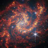 Leuchtend rote und orangene Gas- und Staubwolken in der Spiralgalaxie NGC 2283