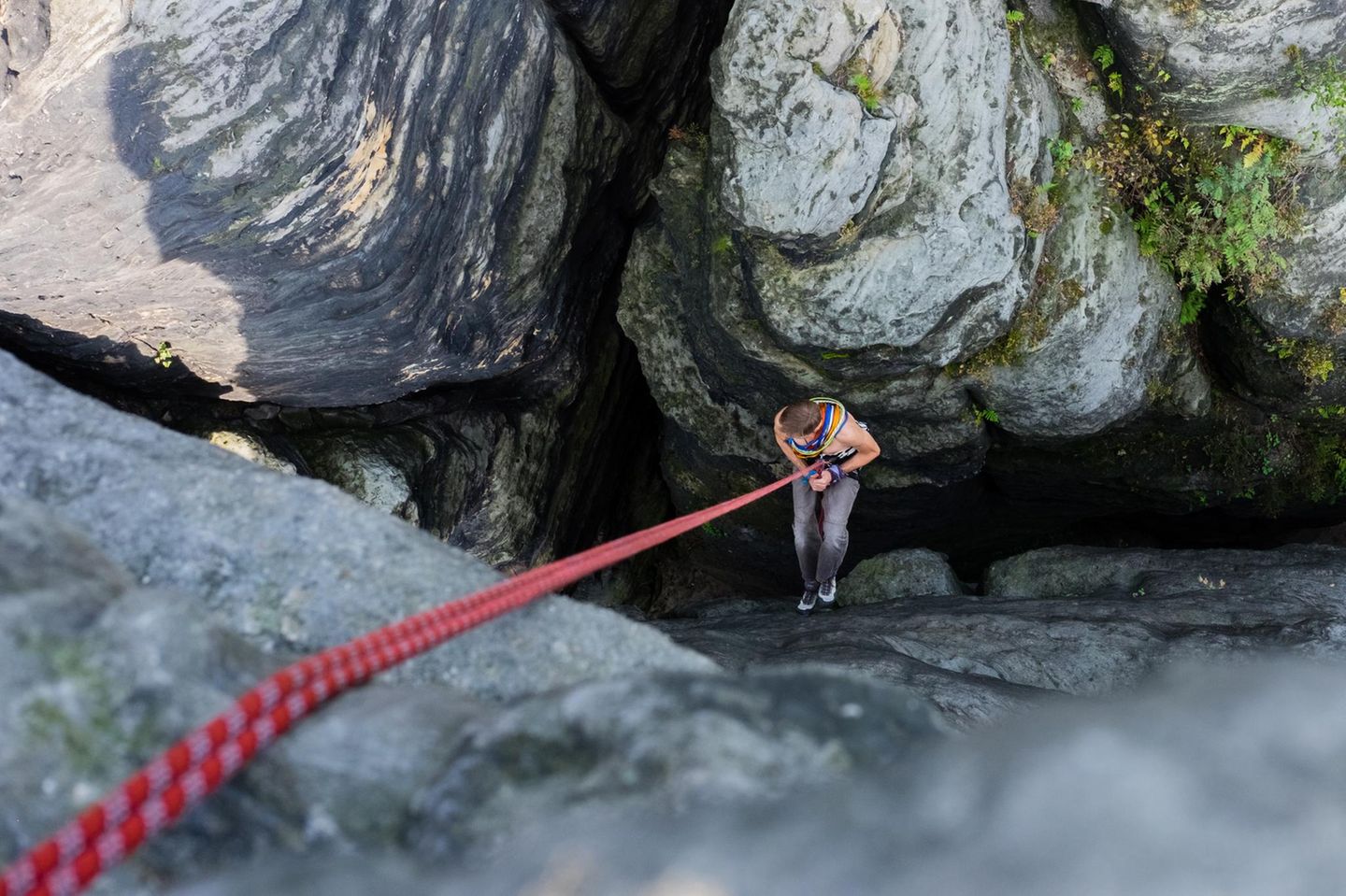 Eine Person in einer Felsspalte am Kletterseil