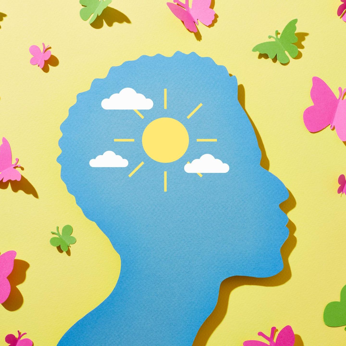 Illustration eines Kopfes umgeben von Sonnenschein und Schmetterlingen