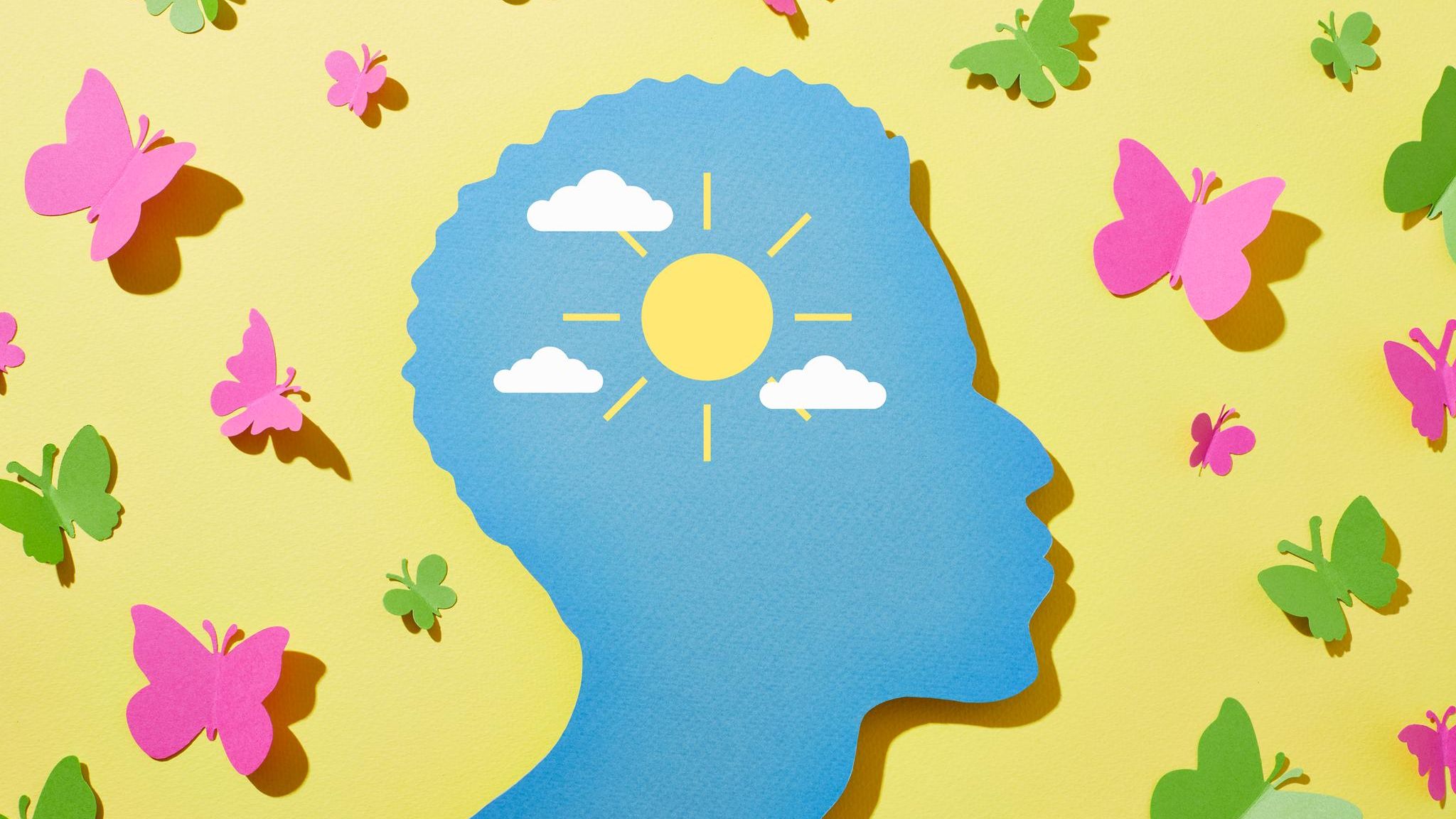 Illustration eines Kopfes umgeben von Sonnenschein und Schmetterlingen