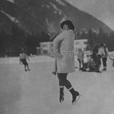 Eine Frau macht auf dem Eis in Chamonix 1924 einen Sprung während sie eine Zigarette raucht