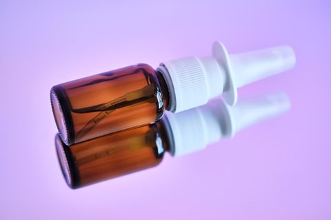 Eine Flasche Nasenspray liegt auf einer spiegelnden Oberfläche