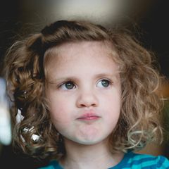 Kind mit Locken guckt kritisch