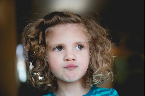 Kind mit Locken guckt kritisch