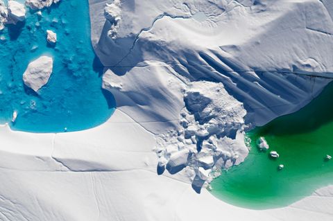 Auf der Oberfläche von Eisflächen und -bergen sammelt sich im Lauf des Sommers Schmelzwasser. Auf dem Drohnenbild gut zu erkennen sind die unterschiedlichen Farbtöne der Tümpel. Klares Meerwasser (links) erscheint in Azurblau, nährstoff- und algenreiches Meerwasser in Grüntönen. Auch dieses Bild entstand in der Diskobucht.