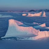 Im Schein der untergehenden Sonne leuchten die Spitzen der im Uummannaq-Fjord eingefrorenen Eisberge noch einmal in zarten Rosa-Tönen auf. "Das Licht, die spirituelle Erhabenheit des Panoramas und wohl auch die schiere Kälte raubten mir vor Ort oft den Atem", schreibt der Fotograf. "Mit der Drohne konnte ich das Spiel der letzten Sonnenstrahlen auf den Eisbergen aus der Vogelperspektive einfangen, während mir die Weite des Eises als bequeme Start- und Landefläche zur Verfügung stand".
