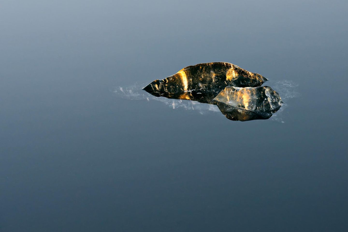 Die Abendsonne lässt einen im Wasser treibenden Eisrest bernsteinfarben aufleuchten. "Mir wird klar, dass gerade die Vergänglichkeit des Eises die Grundlage all seiner Schönheit ist", schreibt der Fotograf zu diesem Bild. "Und dass es damit, als ein in menschlicher Ignoranz vielfach dem unbeseelten Teil der Natur zugerechnetes Phänomen, uns viel näher steht, als wir uns das vielleicht eingestehen mögen."