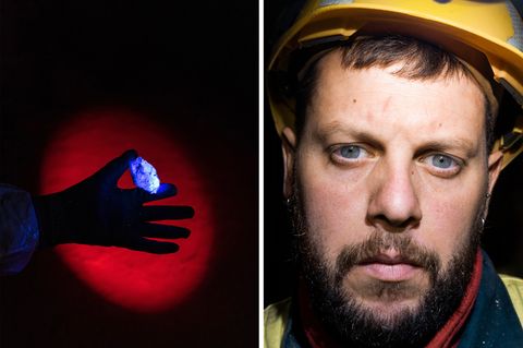 Ein junger Mann mit blauben Augen blickt in die Kamera. Er trägt einen gelben Helm