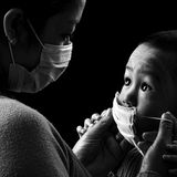 Während der Covid-Pandemie verschwand das Lächeln hinter Masken. Verdeckte Gesichter überall: in der Bahn, im Supermarkt, auf offener Straße. Wie vermittelt man den Kleinsten, dass eine unsichtbare Gefahr droht? Und dass ein dünnes Vlies vor Mund und Nase davor schützen kann? Mit Liebe. Das Bild von Pyae Phyo Htike zeigt eine Mutter in Myanmar, die ihrem Sohn sanft eine Maske aufsetzt. Der Junge schaut sie fragend an, ihr Blick antwortet: Hier geschehen schwer verständliche Dinge. Aber ich bin bei dir und passe auf dich auf