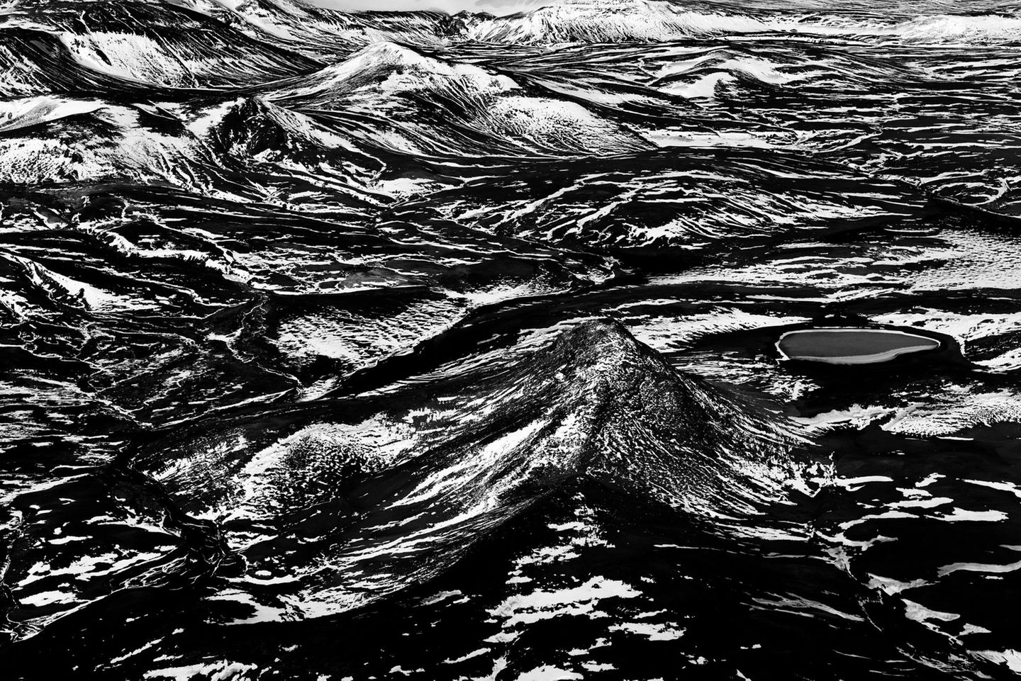 Wie in einem Linolschnitt scheint die Vulkanlandschaft Islands sich scharf in Schwarz oder Weiß zu trennen: Lavageröll und Schneefelder liegen hier dicht and dicht beieinander.