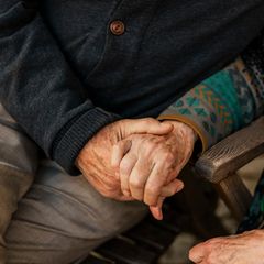 zwei Menschen halten sich an den Händen