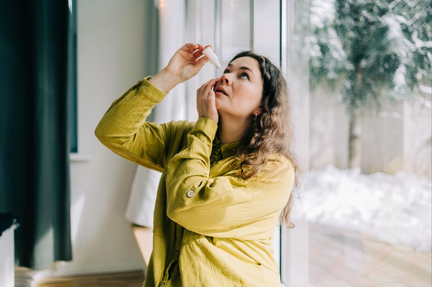 Person benutzt Augentropfen