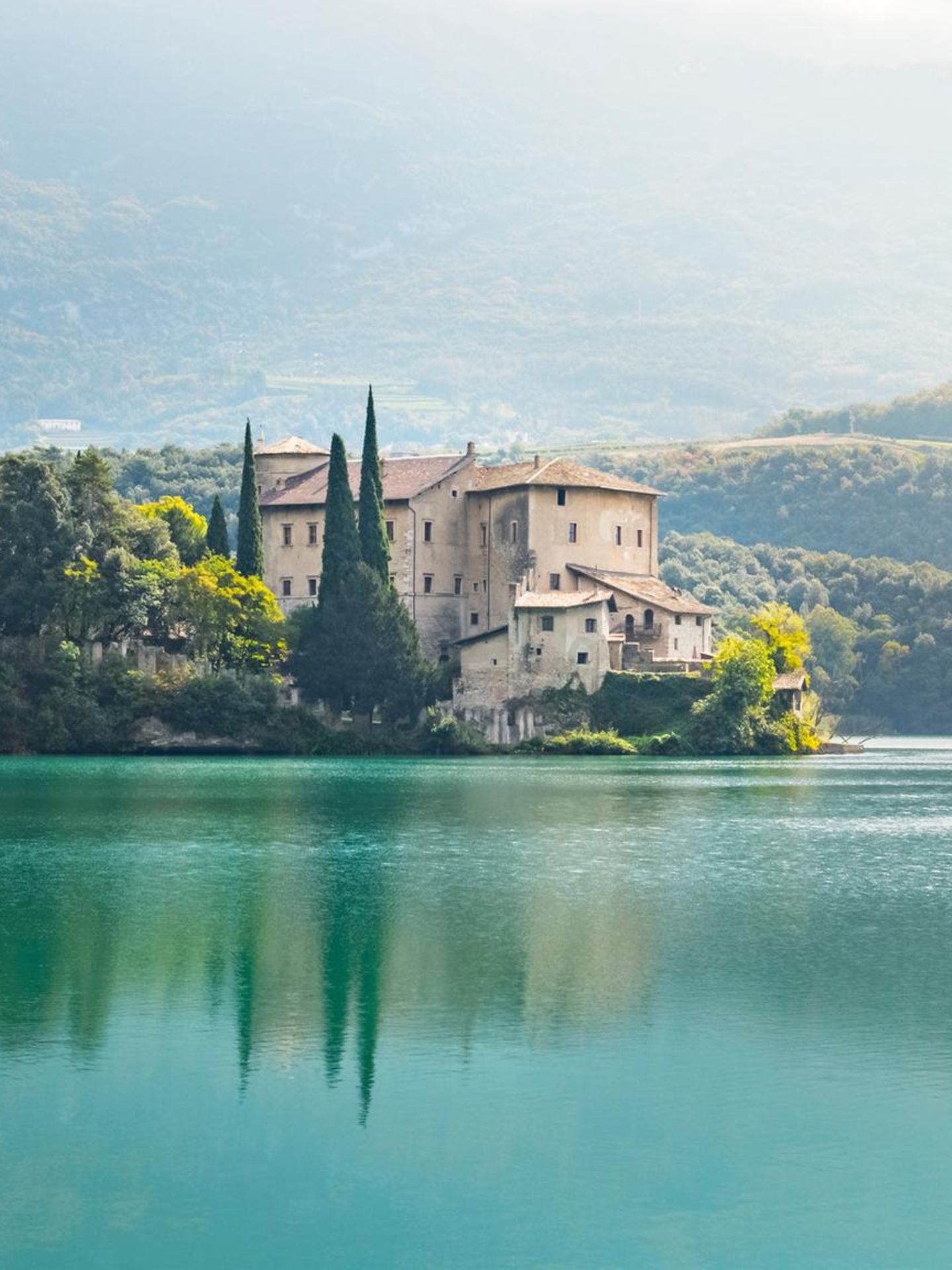 Schon von Weitem spiegelt sich Castel Toblino im türkisblauen Wasser. Zahlreiche Legenden ranken sich um das romantische Schloss, das auf einer Felszunge in den Toblinosee hineinragt. Feen hätten hier gelebt, außerdem soll es ein Liebesversteck des Fürstbischofs Carlo Emanuele Madruzzo und seiner Geliebten Claudia Particella gewesen sein. Im Schloss befindet sich heute ein elegantes Restaurant mit Bar. Das historische Ambiente macht es zu einem besonders stimmungsvollen Ort. Die schönste Zeit, dieses Stück Trentino zu entdecken, ist der Mai: Dann blüht das Valle dei Laghi, das Tal der Seen, nach den stillen Wintermonaten in frischen Farben auf.
