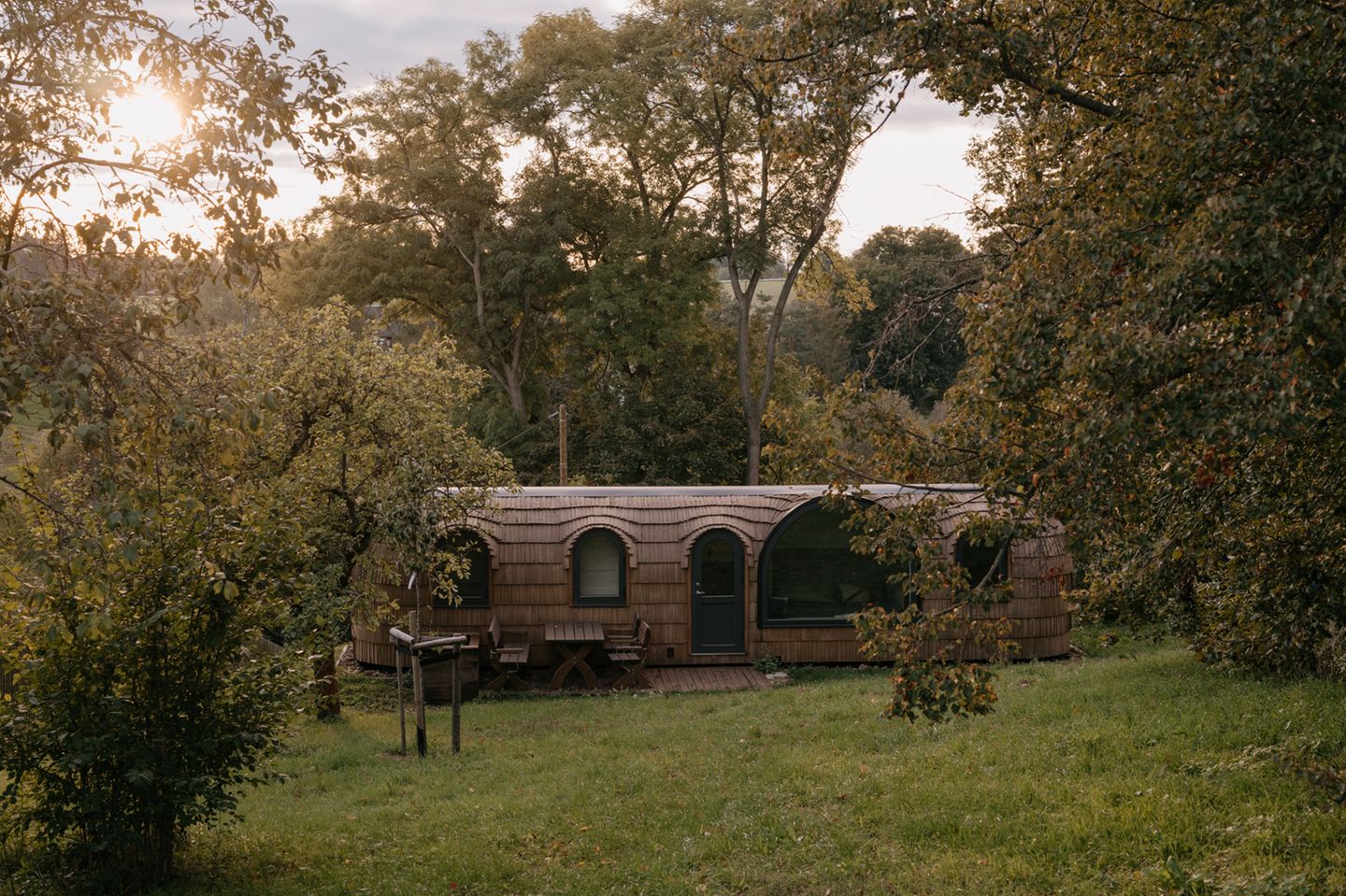 Blick auf Tiny House von Stall und Sterne, daneben Bäume
