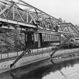 Nach der ersten erfolgreichen Probefahrt 1898 stehen Ingenieure auf einem Wagen der Wuppertaler Schwebebahn