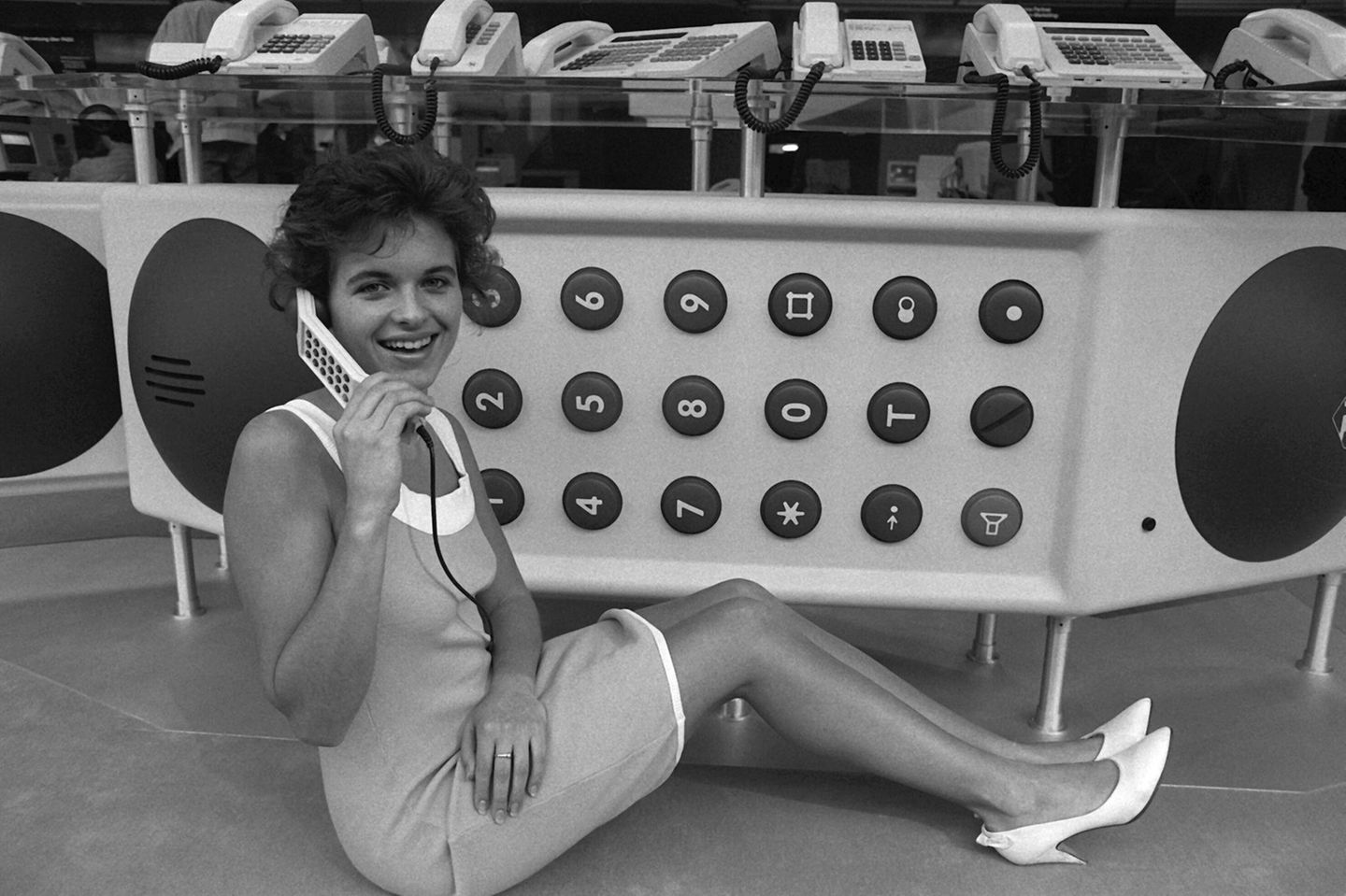 Eine Frau telefoniert vor einem Meter langen Telefon