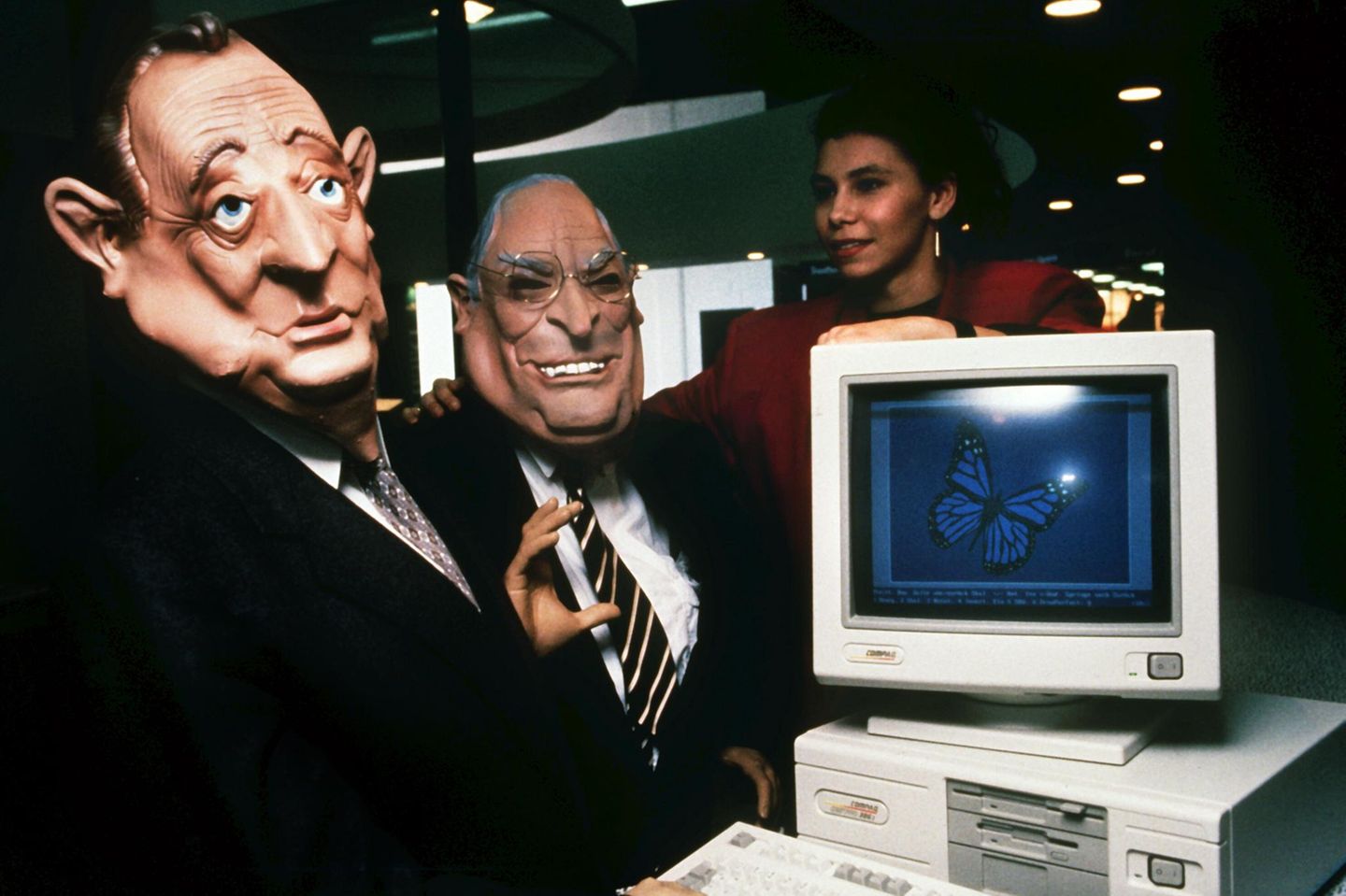 Zwei Männer tragen Masken des Außenministers Hans-Dietrich Genscher und des Bundeskanzlers Helmut Kohl auf der Cebit 1990