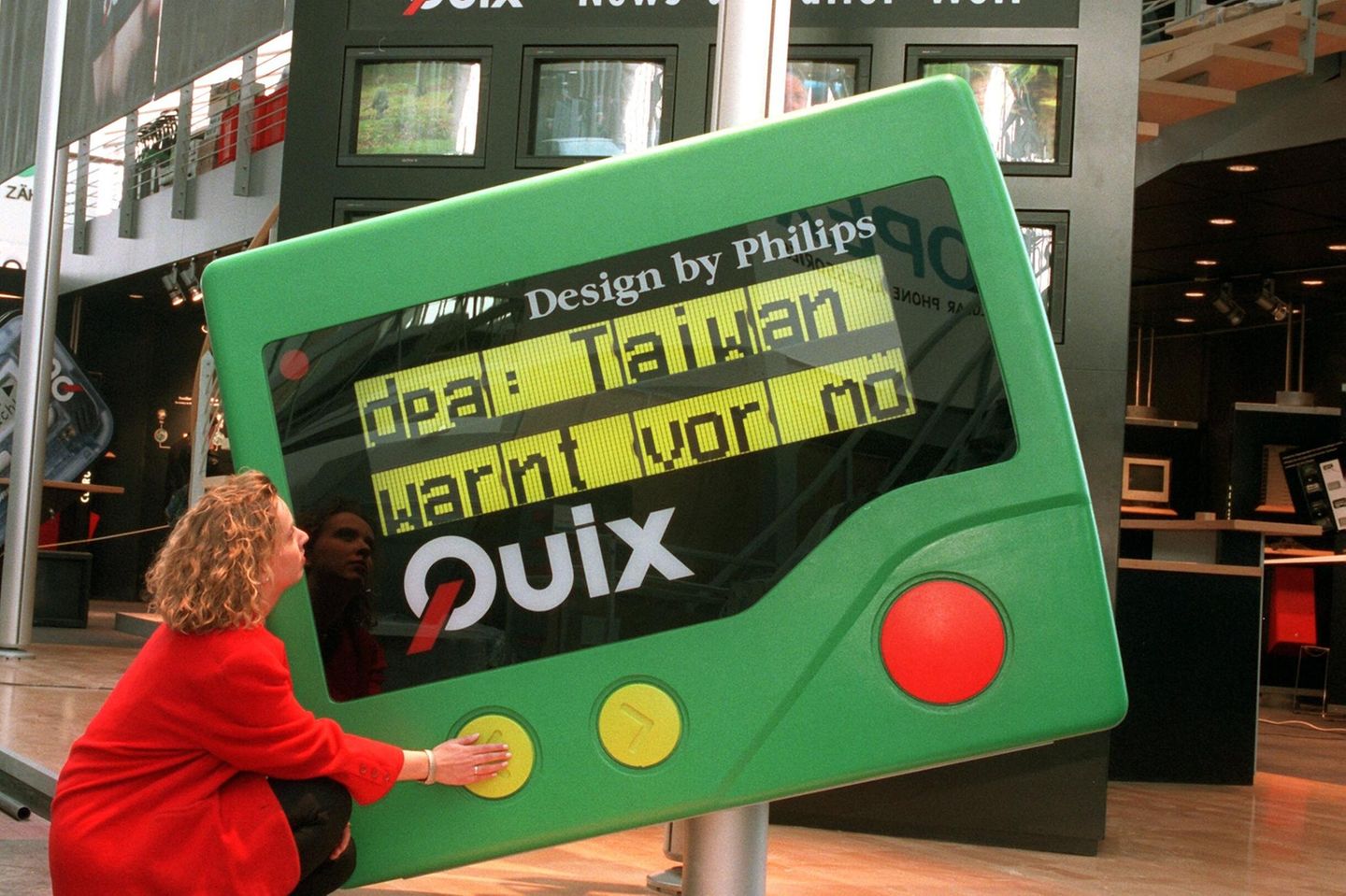 Eine Frau vor einem großen, grünen Pager 1996 auf der Cebit