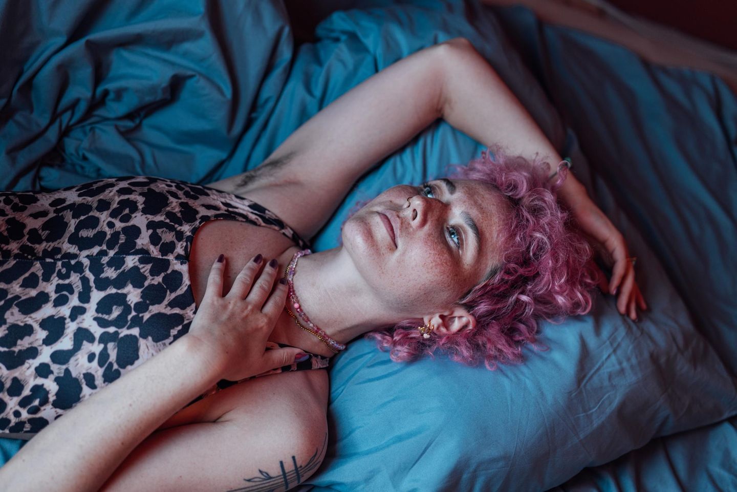 Eine junge Frau liegt verträumt auf ihrem Bett