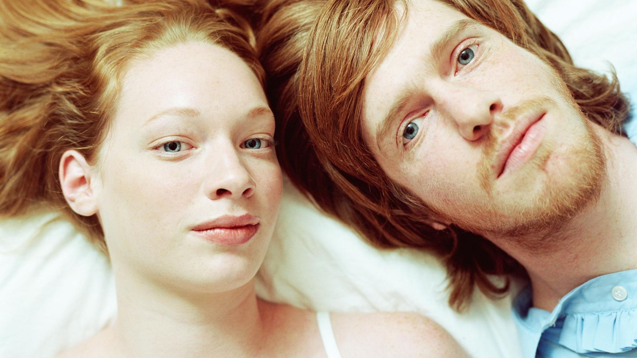 Junges Paar liegt Kopf an Kopf