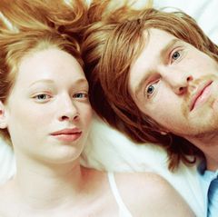 Junges Paar liegt Kopf an Kopf